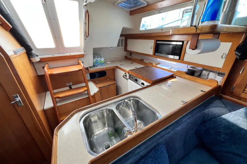 Slide: The Image of Interior of a 1998 Catalina 36 MkII sailboat kitchen with sink, stove, and microwave. - 53