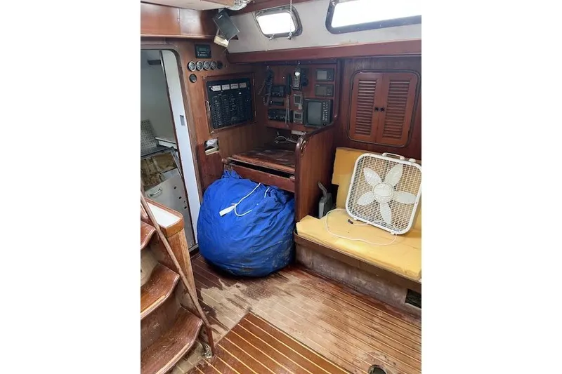 Slide: The Image of 1998 Tayana 55 yacht interior with navigation equipment, wooden flooring, and seating area. - 10