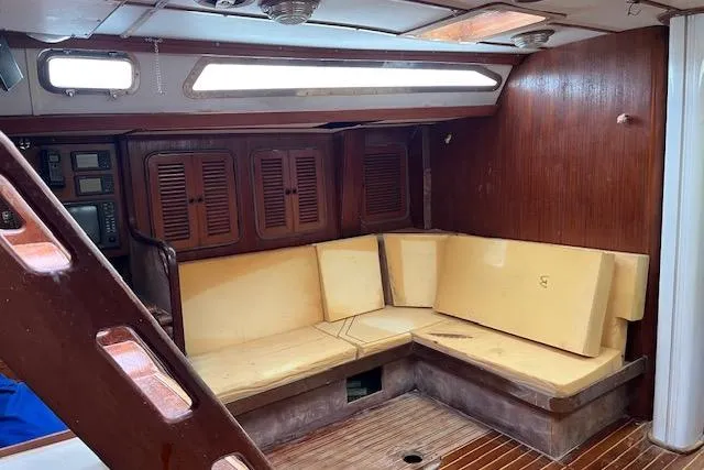 Slide: The Image of Interior of 1998 Tayana 55 yacht with wooden paneling and cushioned seating area. - 11