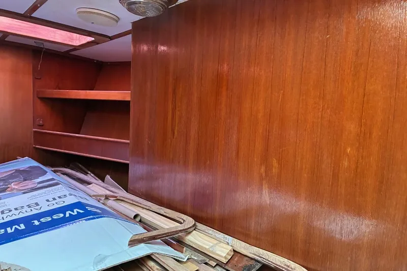 Slide: The Image of Interior of 1998 Tayana 55 sailboat with wooden paneling and storage shelves. - 18