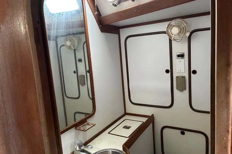 Slide: The Image of Interior of 1998 Tayana 55 yacht bathroom with sink, mirror, and storage cabinets. - 24
