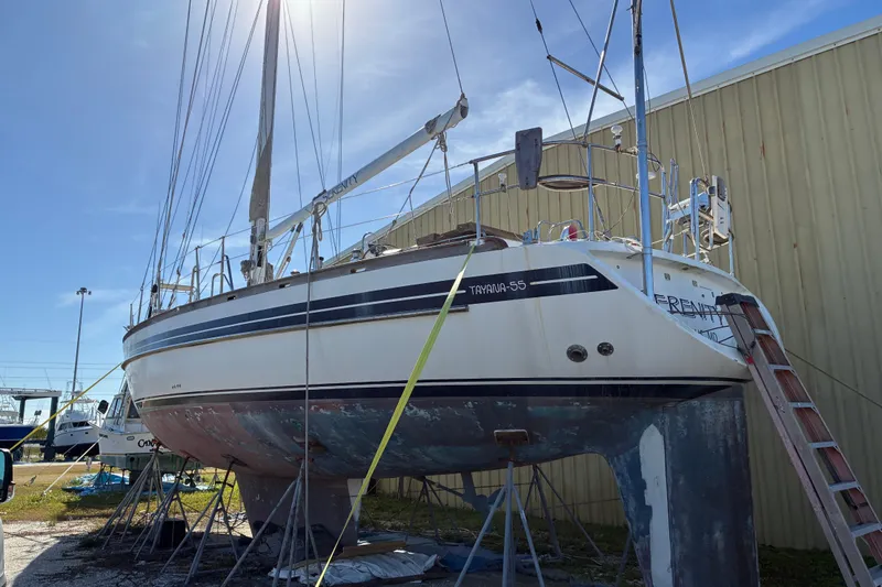 Slide: The Image of 1998 Tayana 55 sailboat on dry dock, undergoing maintenance under clear blue sky. - 3