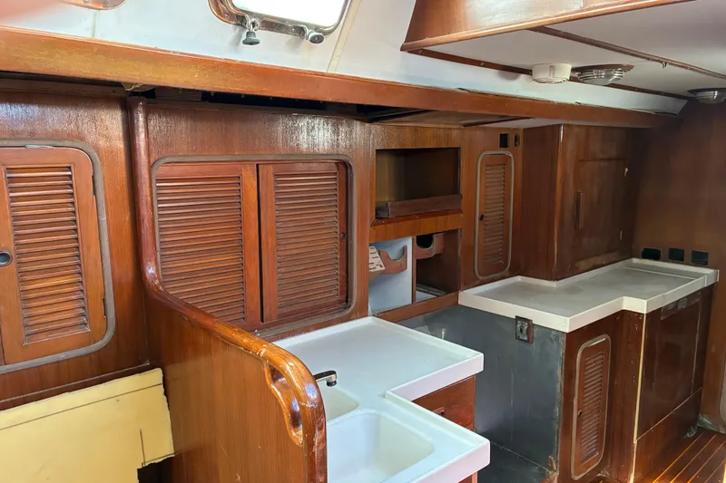 Slide: The Image of Interior of 1998 Tayana 55 yacht with wooden cabinetry and white countertops. - 30