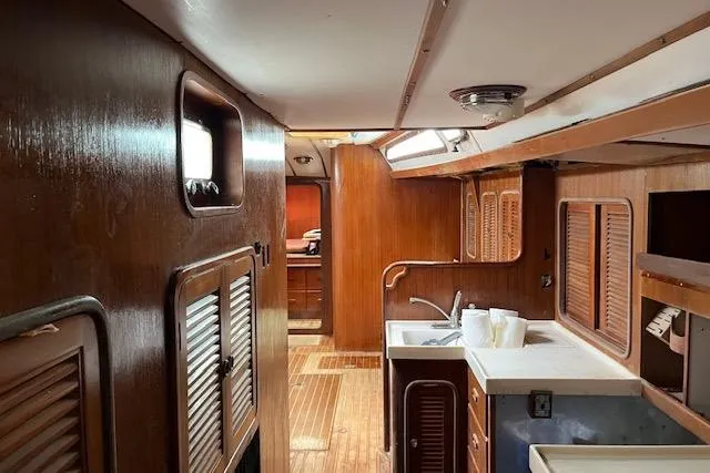 Slide: The Image of Interior of 1998 Tayana 55 yacht with wooden cabinetry and compact kitchen area. - 32