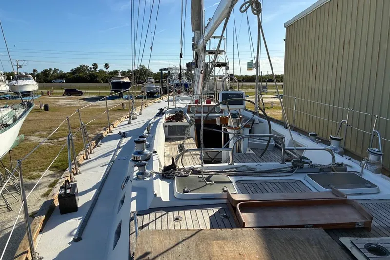 Slide: The Image of Deck view of a 1998 Tayana 55 sailboat in a marina, showcasing rigging and equipment. - 4