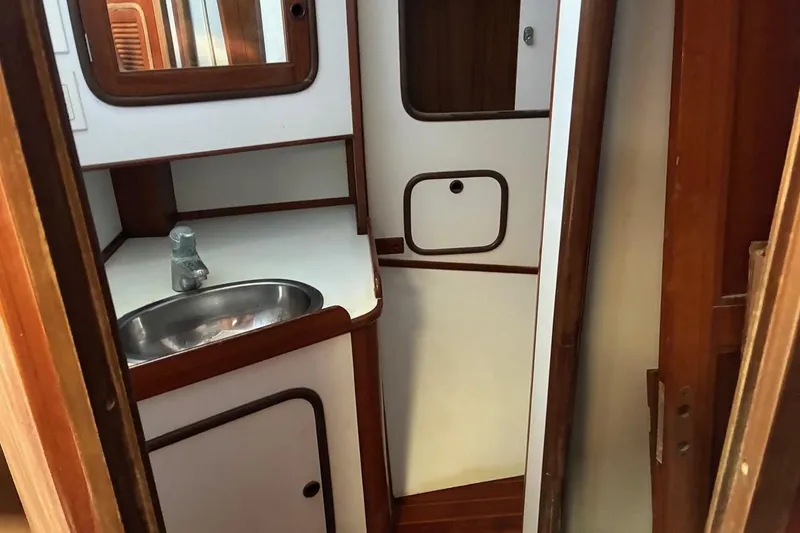 Slide: The Image of Interior of 1998 Tayana 55 yacht featuring a compact bathroom with sink and mirror. - 41
