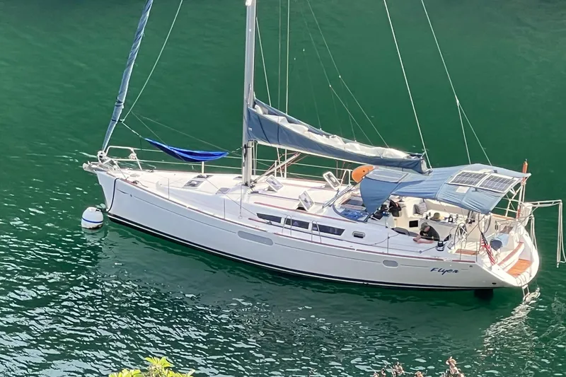 Slide: The Image of 2010 Jeanneau Sun Odyssey 44i sailboat anchored on calm green water. - 26