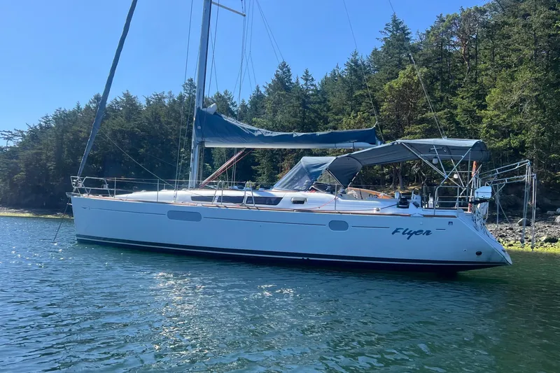 Slide: The Image of 2010 Jeanneau Sun Odyssey 44i sailboat anchored near forested shoreline. - 28