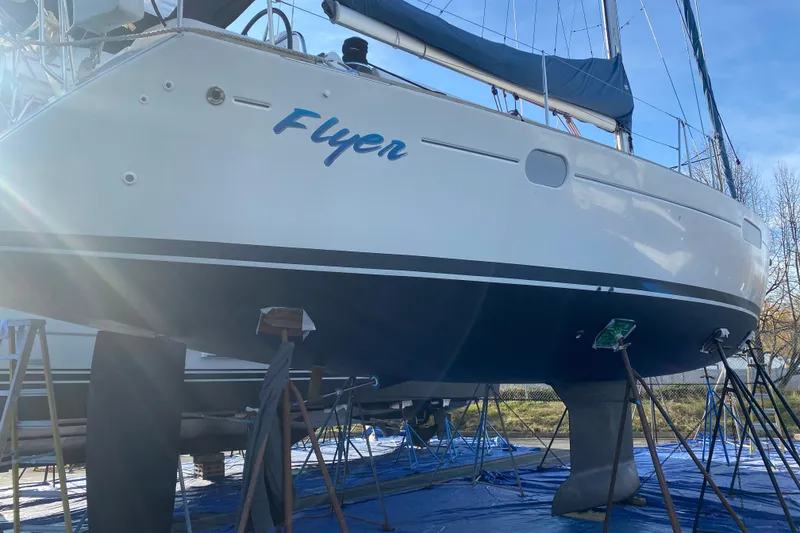 Slide: The Image of 2010 Jeanneau Sun Odyssey 44i sailboat named "Flyer" on dry dock under sunlight. - 33