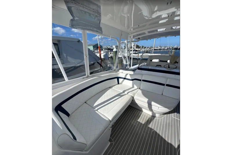 Slide: The Image of 2015 Intrepid 400 Cuddy interior with white seating and marina view. - 13