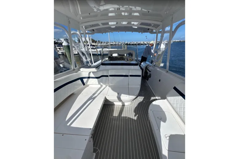 Slide: The Image of 2015 Intrepid 400 Cuddy boat interior with seating and helm, docked at marina. - 18