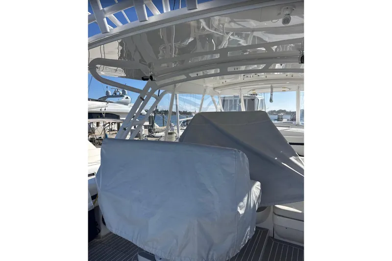 Slide: The Image of 2015 Intrepid 400 Cuddy boat interior with covered seating and helm, docked at marina. - 24