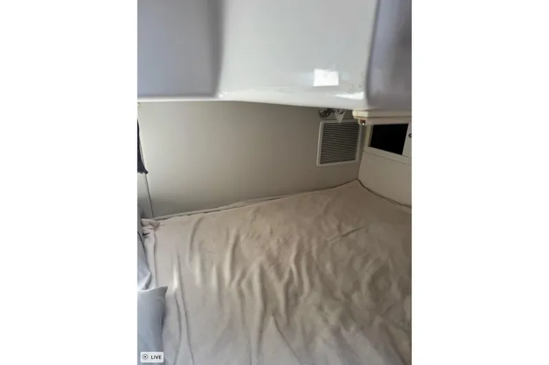 Slide: The Image of 2015 Intrepid 400 Cuddy cabin interior with beige bedding and wall vent. - 28