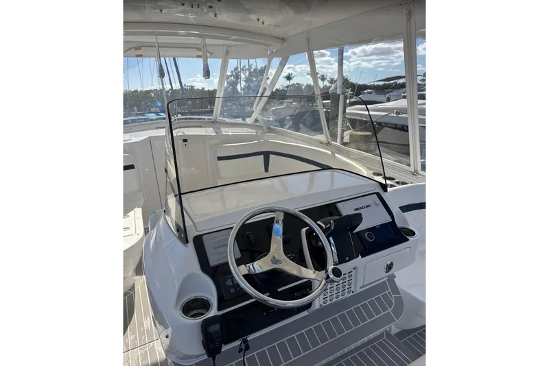 Slide: The Image of 2015 Intrepid 400 Cuddy boat helm with steering wheel and navigation controls. - 5