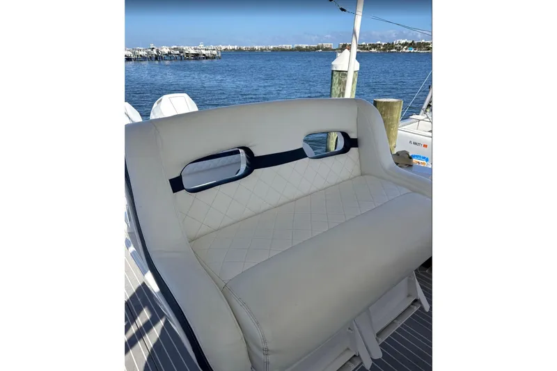 Slide: The Image of Luxury seating on 2015 Intrepid 400 Cuddy boat, docked by the water. - 6