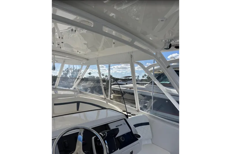 Slide: The Image of 2015 Intrepid 400 Cuddy boat interior with steering wheel and clear canopy. - 7