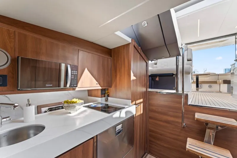 Slide: The Image of Modern kitchen interior on 2026 Valiatt 410 HT yacht, featuring wood cabinetry and sleek appliances. - 6