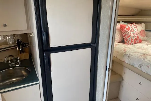 Slide: The Image of Interior of a 1995 Regal 402 boat with kitchenette and cozy bedroom. - 10