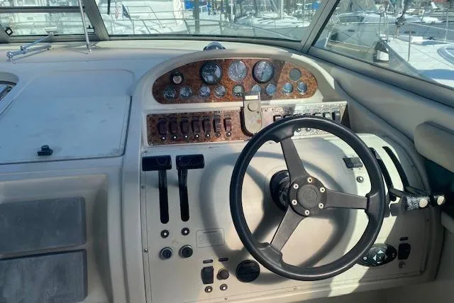 Slide: The Image of 1995 Regal 402 boat dashboard with steering wheel and control panel. - 6
