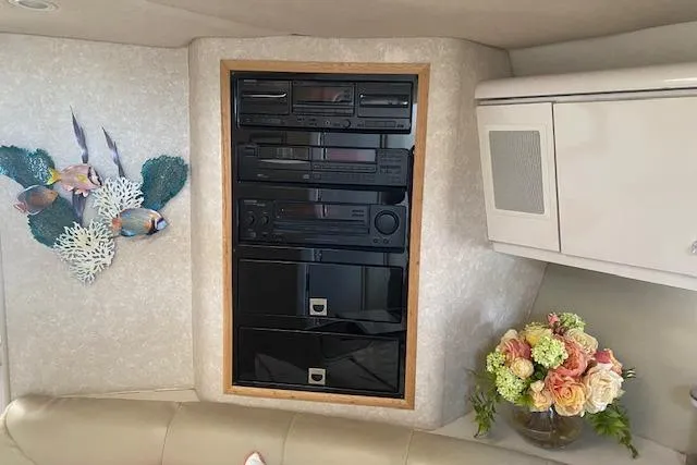 Slide: The Image of Entertainment system in a 1995 Regal 402 boat interior with floral decor and fish wall art. - 9