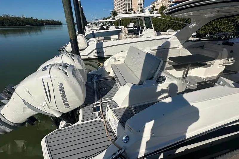 Slide: The Image of 2020 Sea Ray SLX 350 Outboard docked, featuring twin Mercury engines and spacious seating. - 13