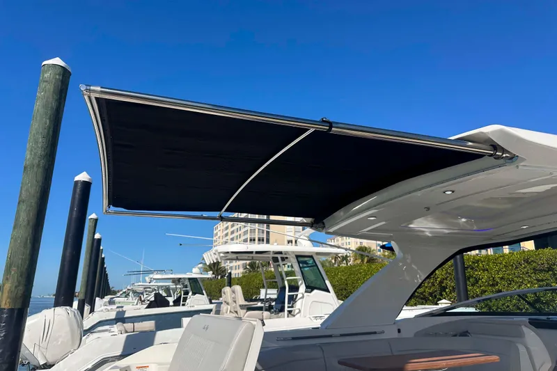 Slide: The Image of 2020 Sea Ray SLX 350 Outboard with extended sunshade at marina. - 16