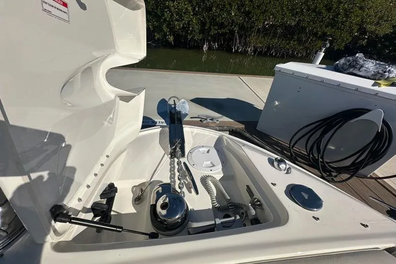 Slide: The Image of 2020 Sea Ray SLX 350 Outboard anchor compartment with chain and winch, docked near mangroves. - 23