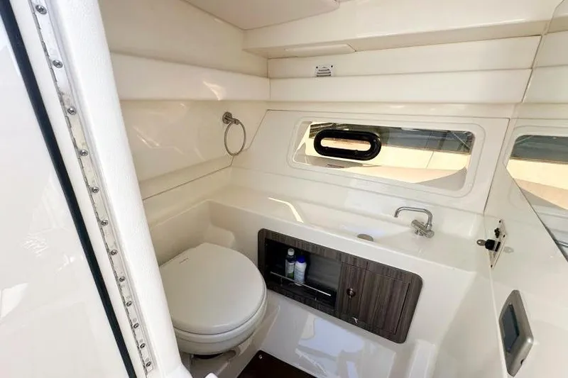 Slide: The Image of 2020 Sea Ray SLX 350 Outboard bathroom with toilet, sink, and window. - 26