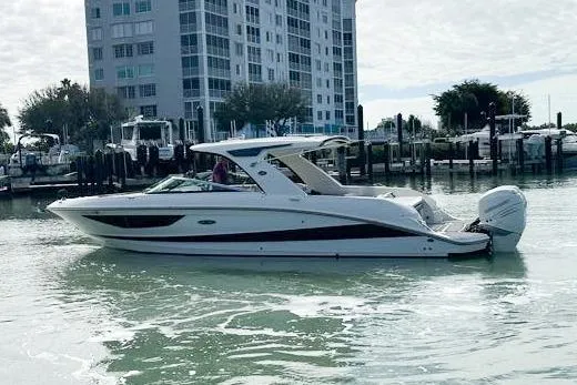 Slide: The Image of 2020 Sea Ray SLX 350 Outboard boat on water near a marina and building. - 3