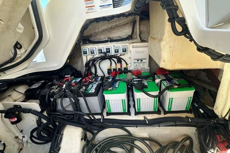 Slide: The Image of 2020 Sea Ray SLX 350 Outboard battery compartment with multiple batteries and wiring. - 31