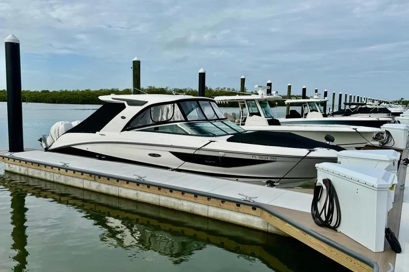 Slide: The Image of 2020 Sea Ray SLX 350 Outboard docked at marina, calm waters, overcast sky. - 34