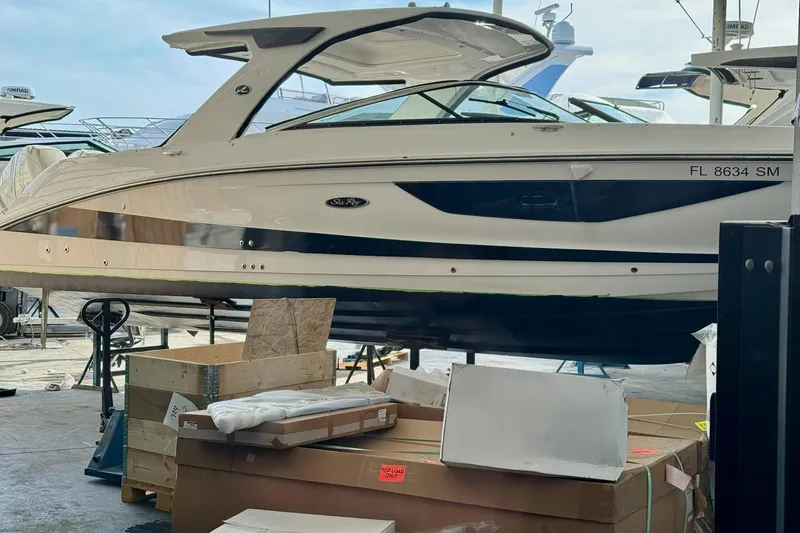 Slide: The Image of 2020 Sea Ray SLX 350 Outboard boat in a marina with packaging materials. - 36