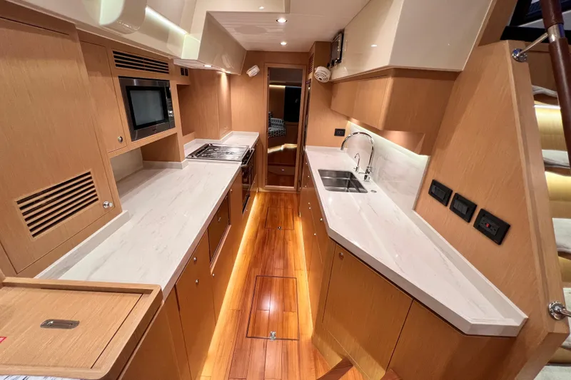 Slide: The Image of Luxurious 2024 Hylas H57 yacht kitchen with modern appliances and sleek wooden cabinetry. - 16