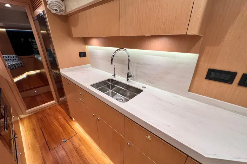 Slide: The Image of Modern galley kitchen in 2024 Hylas H57 yacht with sleek countertops and stainless steel sink. - 18