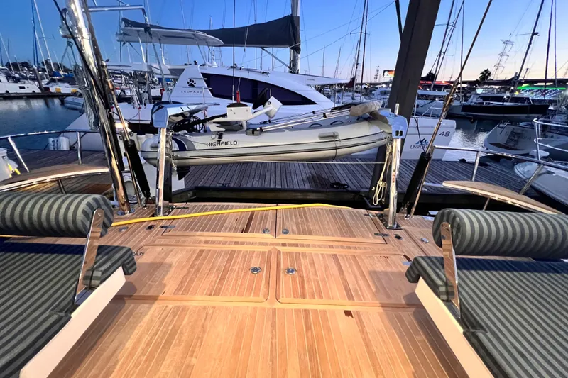 Slide: The Image of 2024 Hylas H57 yacht deck with tender, docked at marina during sunset. - 46