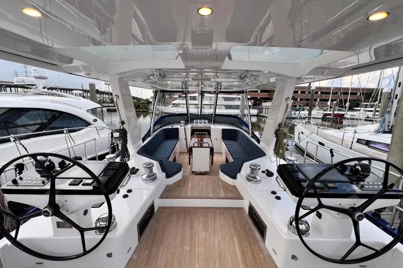 Slide: The Image of Luxurious 2024 Hylas H57 yacht cockpit with dual steering wheels and elegant seating. - 59