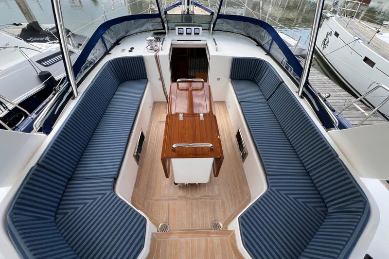 Slide: The Image of Luxurious 2024 Hylas H57 yacht cockpit with striped seating and wooden table. - 61