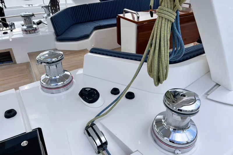 Slide: The Image of 2024 Hylas H57 yacht deck with winches and ropes, featuring sleek seating. - 67