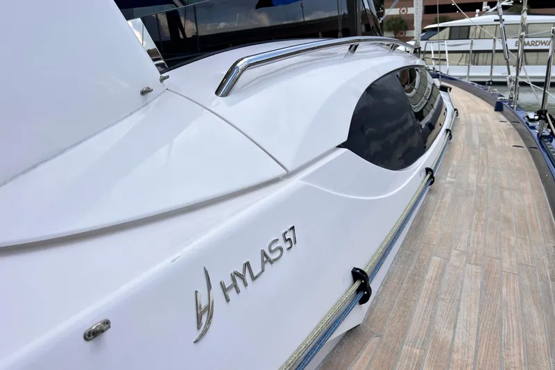 Slide: The Image of 2024 Hylas H57 yacht with sleek design and wooden deck, docked at marina. - 68