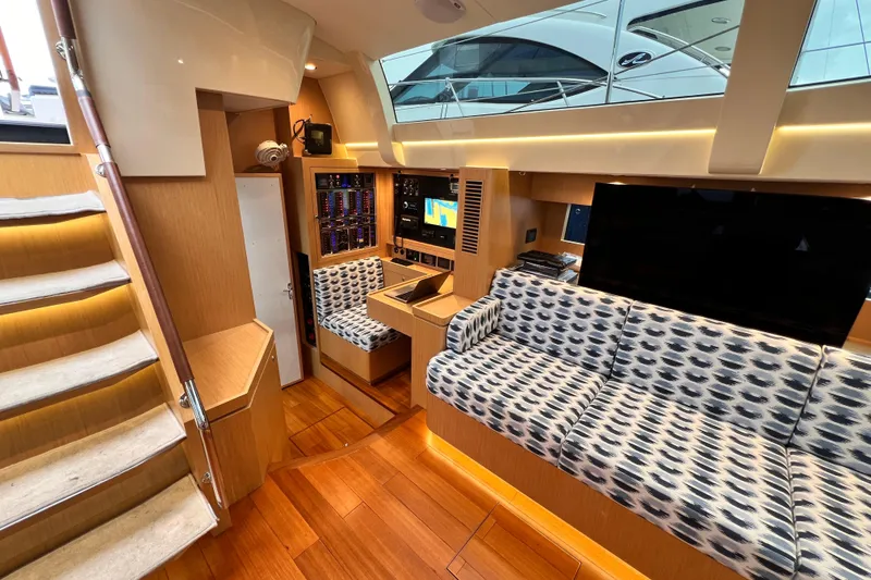 Slide: The Image of 2024 Hylas H57 yacht interior with modern seating, wood flooring, and navigation equipment. - 85