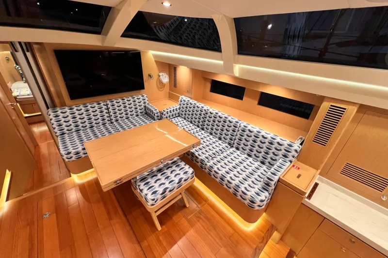 Slide: The Image of 2024 Hylas H57 yacht interior with patterned seating and wooden table. - 9