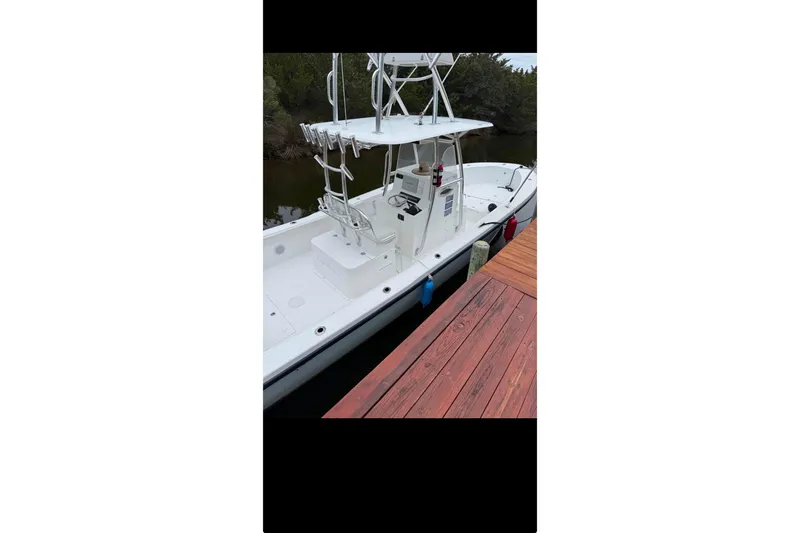 Slide: The Image of 2021 Ocean Master 27 boat docked, featuring a sleek white design and spacious deck. - 3