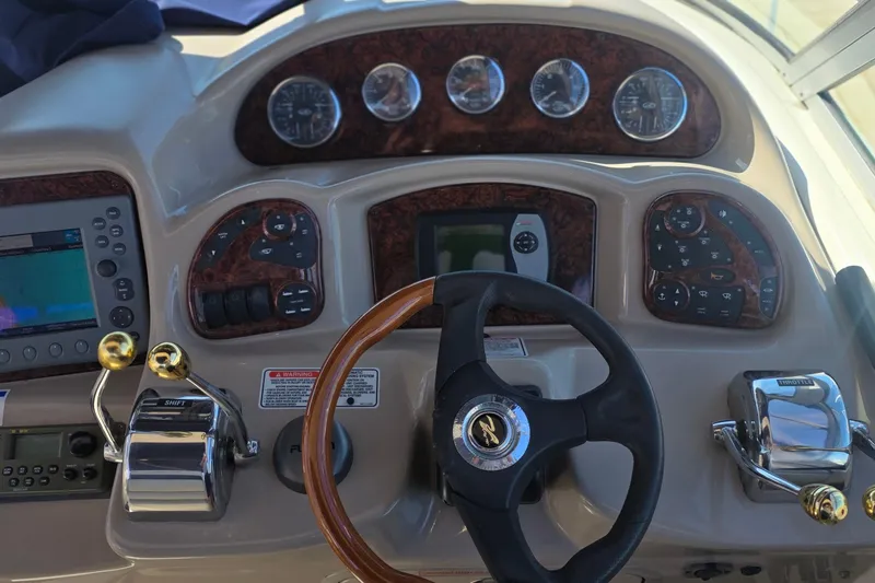Slide: The Image of Control panel of a 2005 Sea Ray 340 Sundancer boat with steering wheel and gauges. - 14