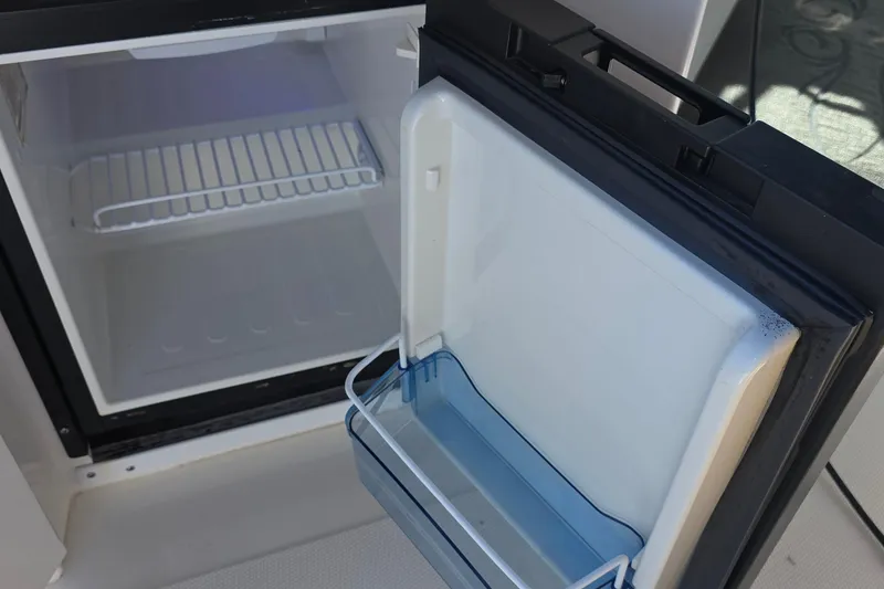 Slide: The Image of Open refrigerator on 2005 Sea Ray 340 Sundancer boat, showing interior shelves and door storage. - 20