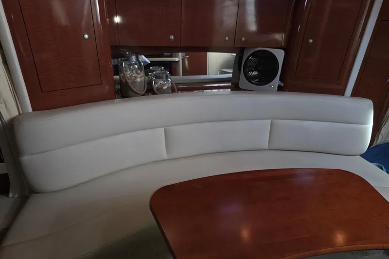 Slide: The Image of Interior of 2005 Sea Ray 340 Sundancer with curved seating and wooden table. - 27