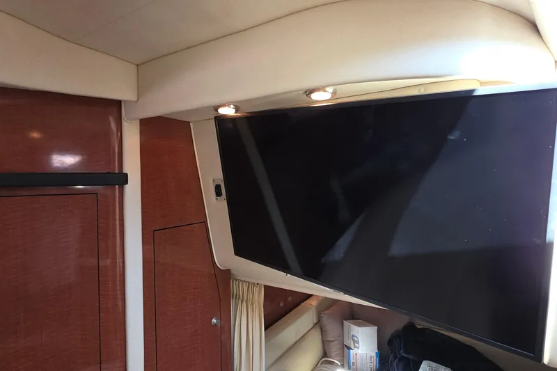 Slide: The Image of Interior of 2005 Sea Ray 340 Sundancer with mounted TV and wood paneling. - 28