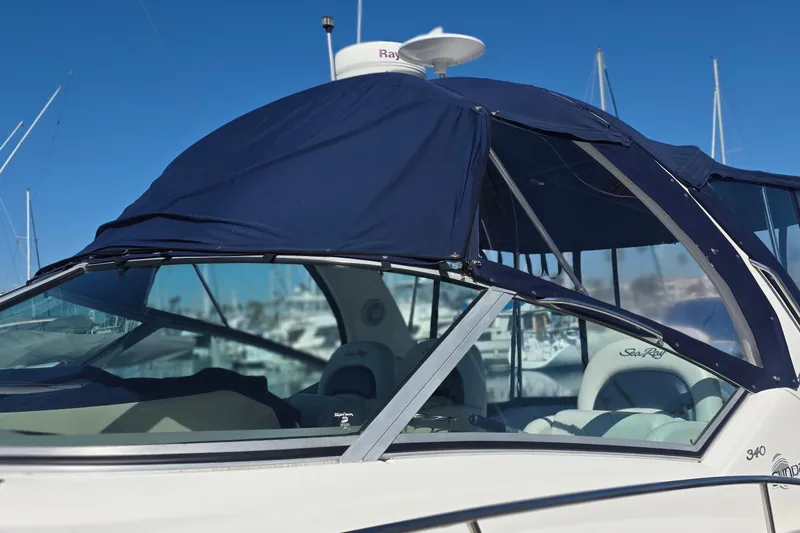 Slide: The Image of 2005 Sea Ray 340 Sundancer boat with blue canopy in marina setting. - 3