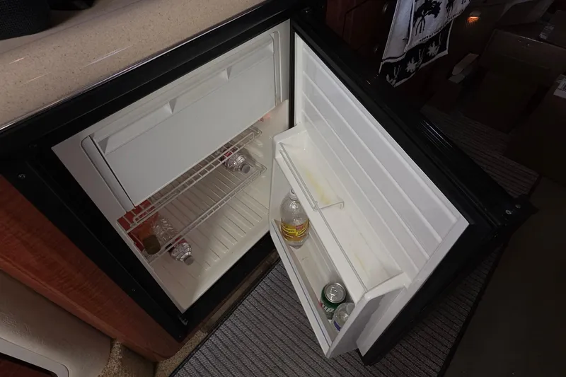 Slide: The Image of Open mini fridge inside 2005 Sea Ray 340 Sundancer boat, containing drinks and bottles. - 30