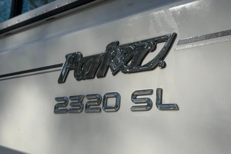 Slide: The Image of 2020 Parker 2320 SL Sport Cabin boat with outboard motor in a garden setting. - 13