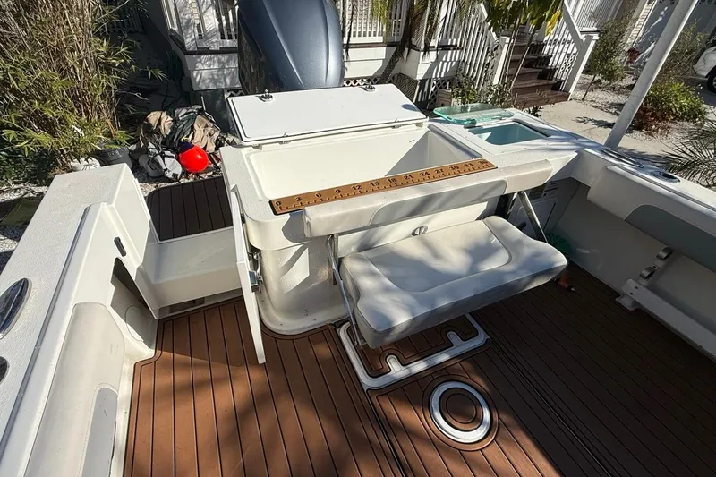 Slide: The Image of Open storage compartment on 2020 Parker 2320 SL Sport Cabin boat with measuring ruler. - 15